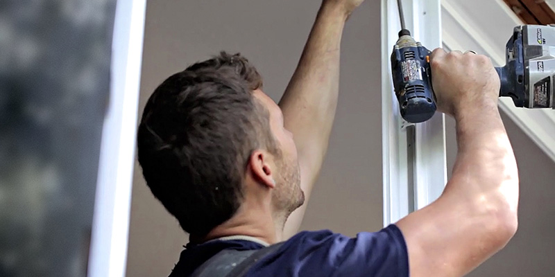 A window installer putting a casement window into a brick house.